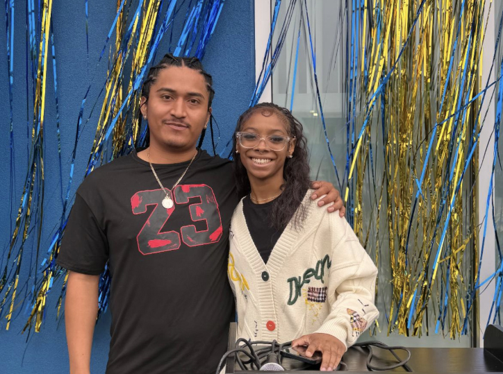 Casa Colibri Grand Opening - photo of two smiling people in front of blue and gold streamers on a blue wall